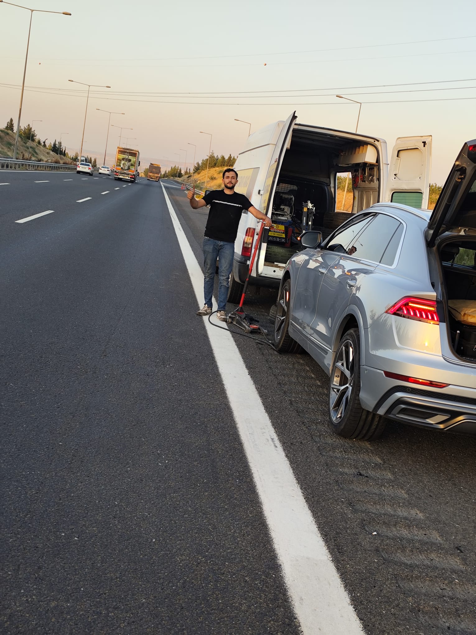 Gün batımında yol kenarı lastik değişimi